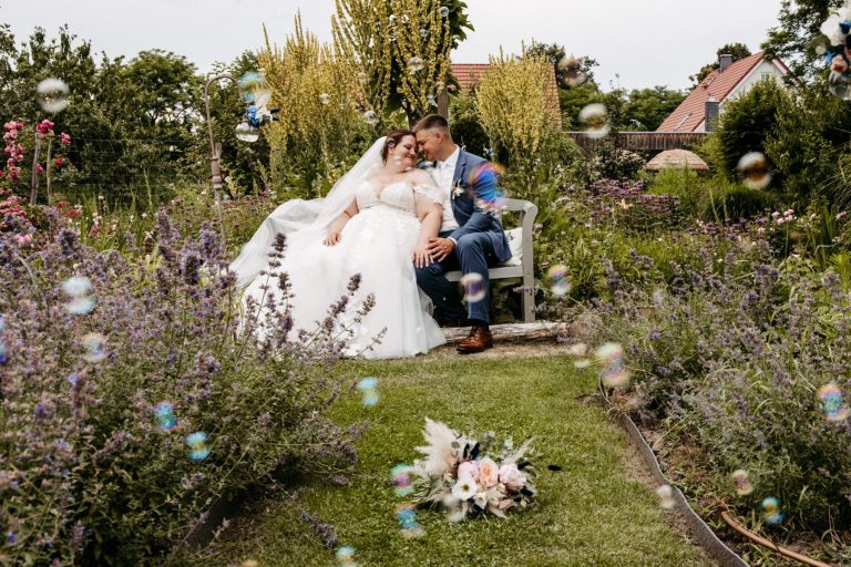 Brautpaar Alwine, sitzend auf Bank im Garten